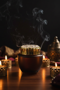 Amber bakhoor jar dark candlelight lifestyle shot